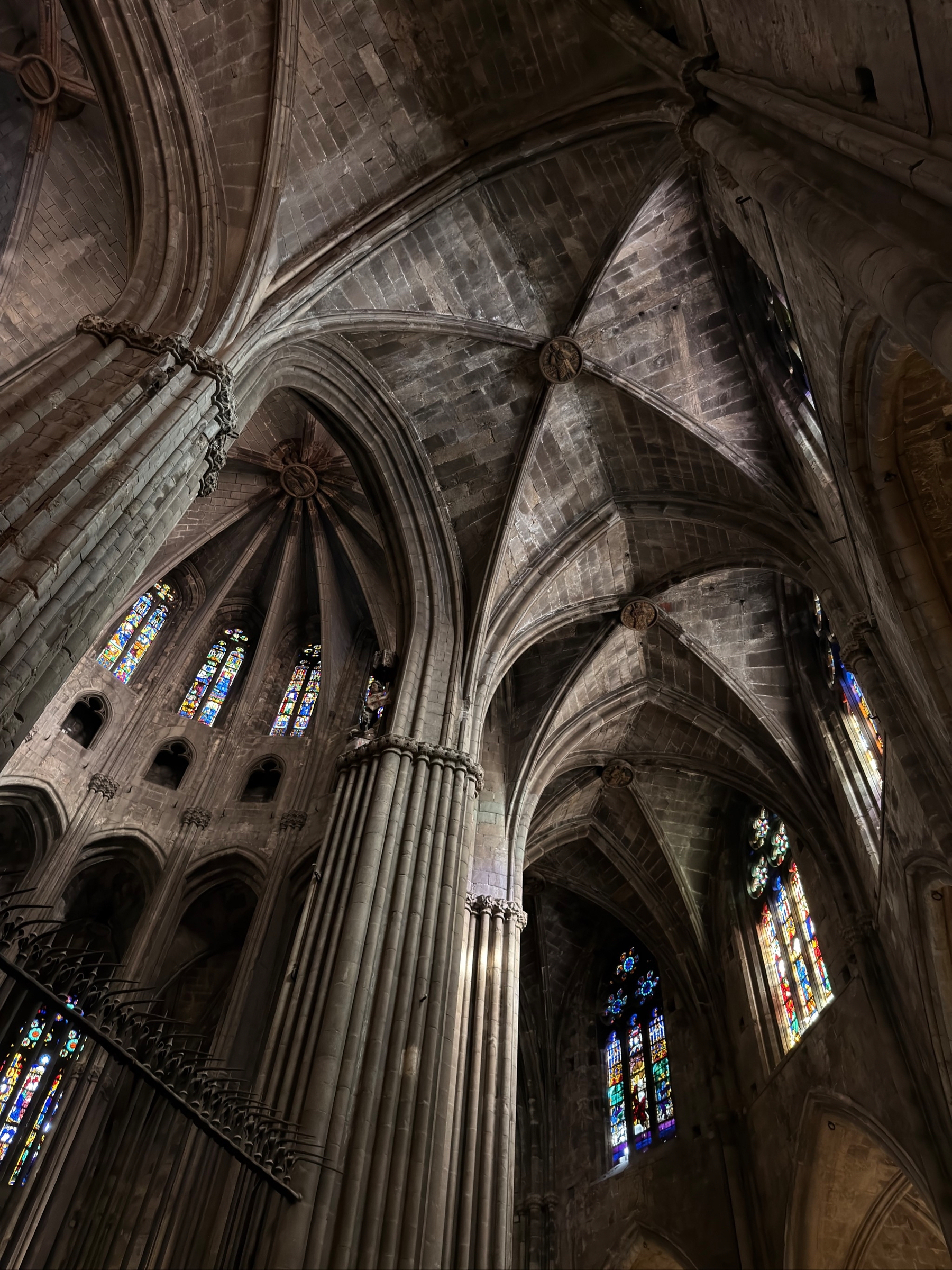 Gothic cathedral interior showcasing tall, ribbed vaults and stained glass windows.